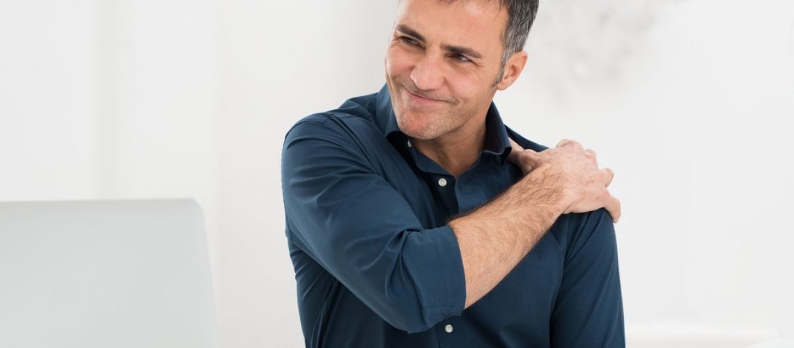 Portrait Of Mature Man At Work Suffering From Shoulder Pain