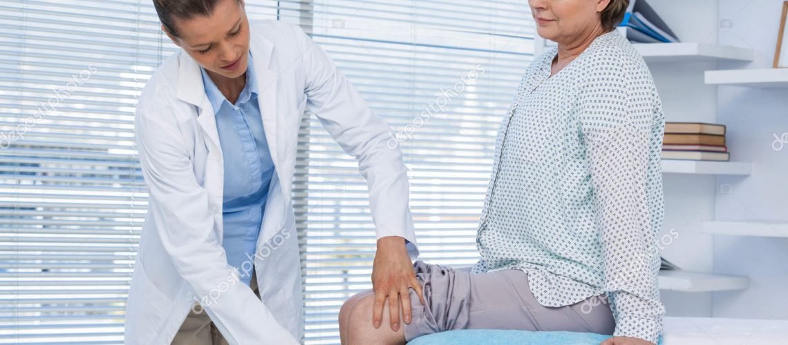 Doctor examining patient knee in clinic